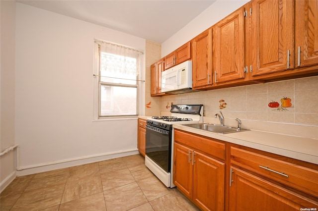 kitchen featuring backsplash, sink, light tile patterned flooring, and white appliances