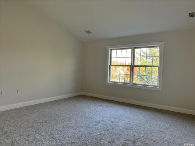 unfurnished room featuring carpet floors and vaulted ceiling