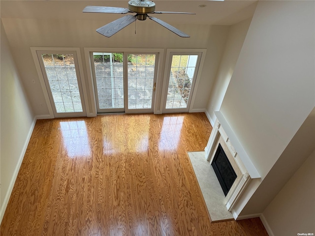 unfurnished living room with ceiling fan and light wood-type flooring