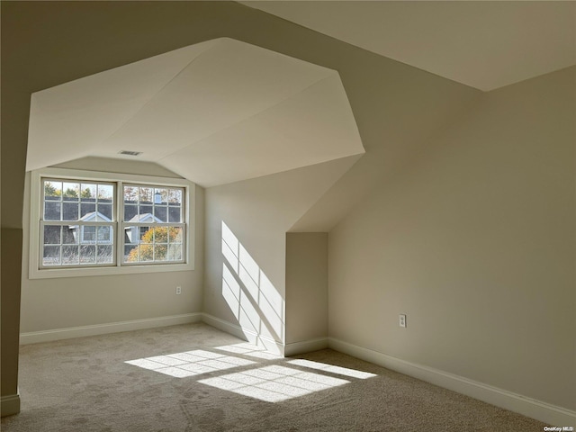 bonus room featuring light colored carpet and vaulted ceiling