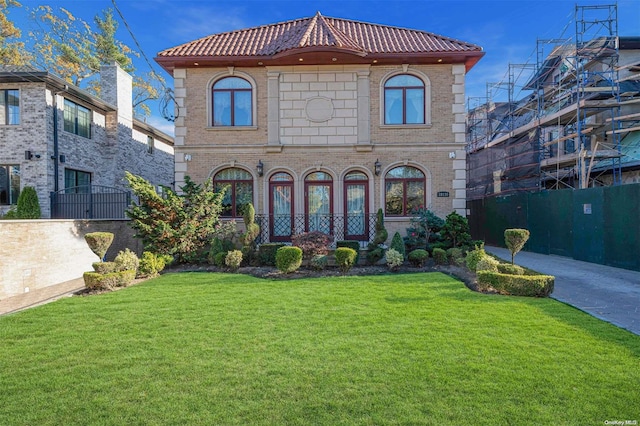 mediterranean / spanish home featuring a front yard