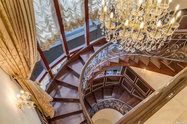 staircase with tile patterned floors and a chandelier