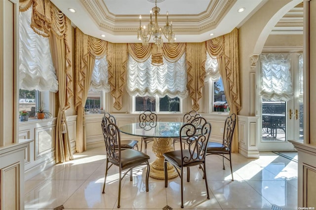 dining area featuring a chandelier, a raised ceiling, crown molding, and light tile patterned flooring