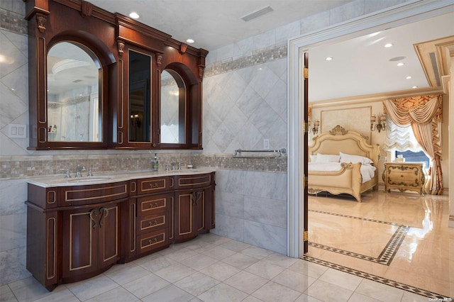 bathroom featuring tile patterned floors, vanity, crown molding, and tile walls