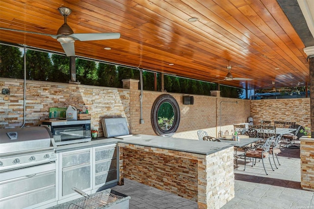 view of patio / terrace with ceiling fan, area for grilling, an outdoor bar, and grilling area