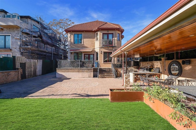 rear view of property with a lawn and a patio area