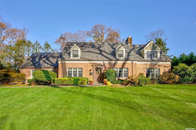 cape cod house featuring a front yard