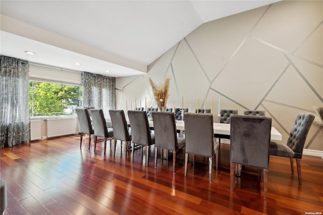 dining area with wood-type flooring, radiator, and vaulted ceiling