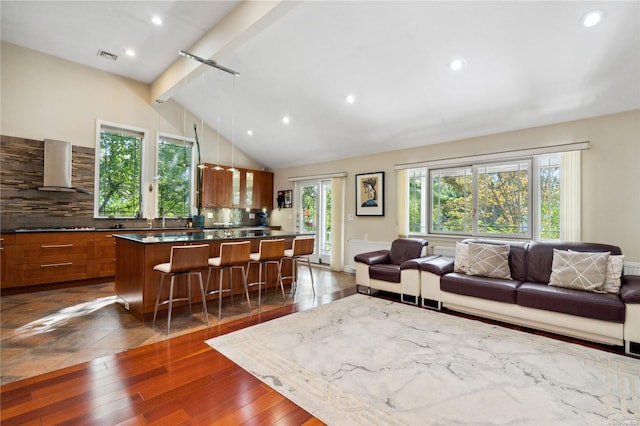 living room with beam ceiling, sink, dark wood-type flooring, and high vaulted ceiling