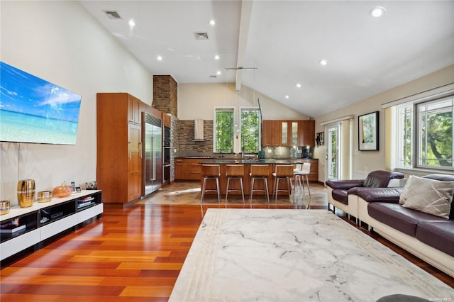 living room with hardwood / wood-style floors, plenty of natural light, and lofted ceiling with beams