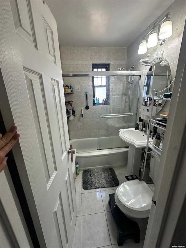 bathroom with shower / bath combination with glass door and tile patterned floors