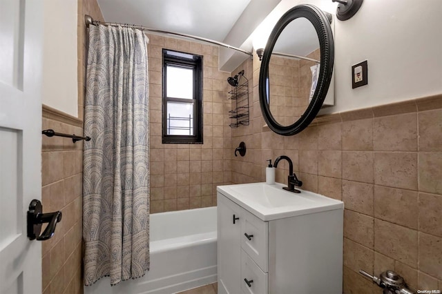 bathroom with shower / bath combo, tile walls, and vanity