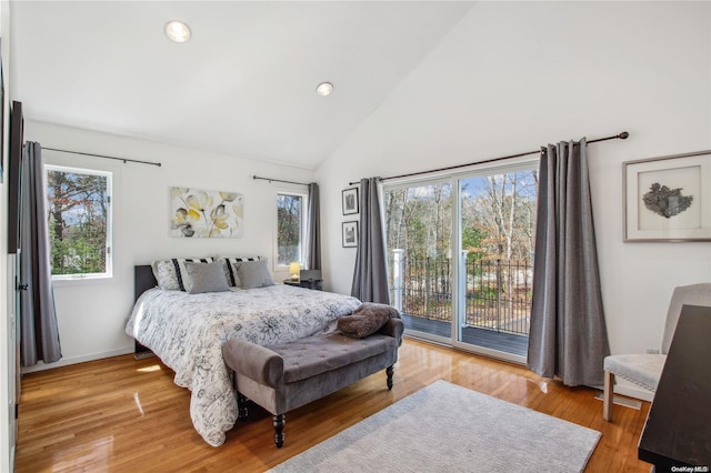 bedroom featuring hardwood / wood-style floors, access to exterior, and multiple windows