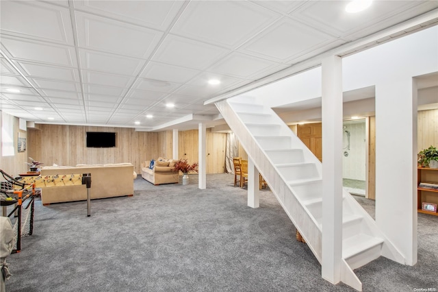 unfurnished living room with carpet and wooden walls