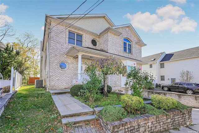 view of front of property with central AC and a front yard