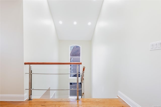 stairs with wood-type flooring and vaulted ceiling