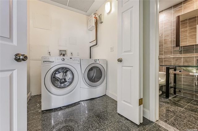 laundry area featuring washer and dryer and tile walls