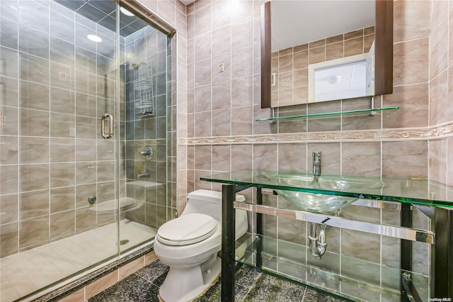 bathroom with a shower with shower door, tile walls, and toilet