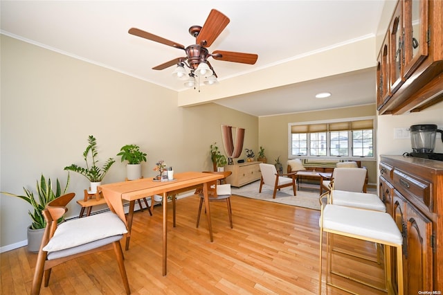 dining space with light hardwood / wood-style floors, ceiling fan, and crown molding