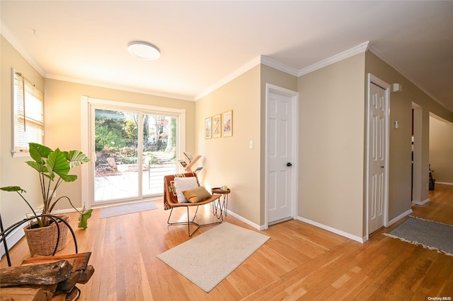 sitting room featuring ornamental molding and hardwood / wood-style flooring