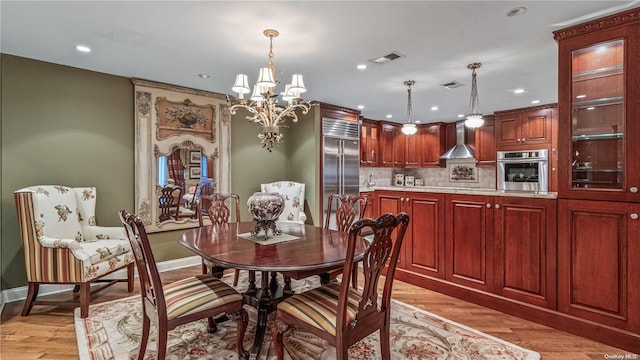 dining space with a notable chandelier and light hardwood / wood-style floors