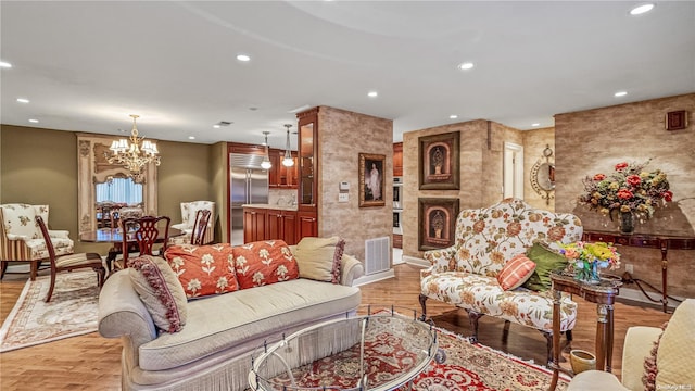 living room featuring a chandelier and light hardwood / wood-style flooring