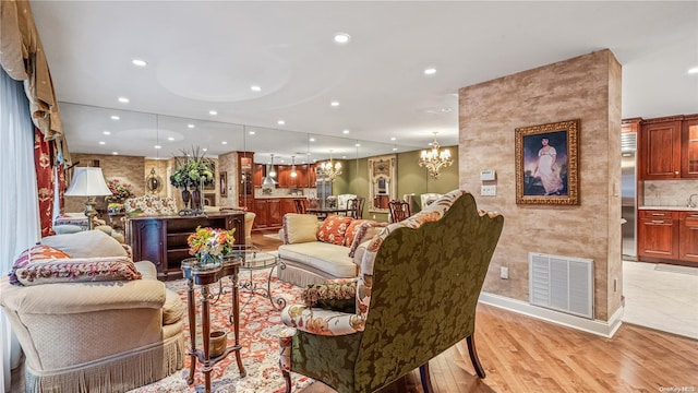 living room featuring a notable chandelier and light hardwood / wood-style flooring