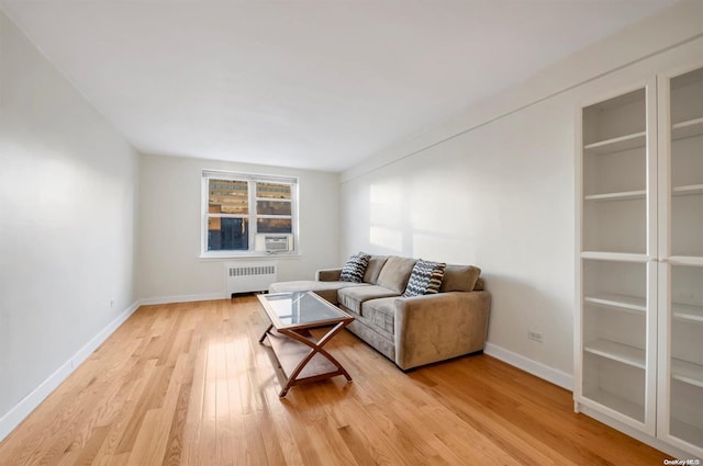 living room featuring light hardwood / wood-style flooring, radiator, and cooling unit