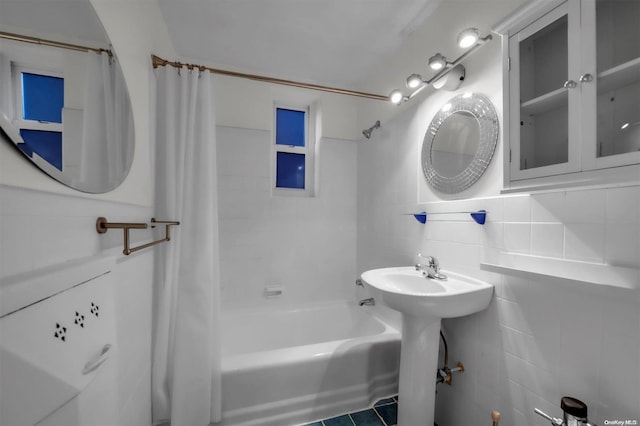 bathroom featuring tile patterned floors, shower / bath combo, tile walls, and tasteful backsplash