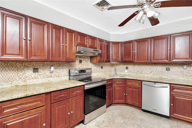 kitchen with stainless steel appliances, light stone counters, tasteful backsplash, and sink