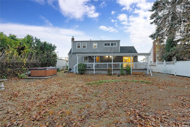 back of property featuring a hot tub