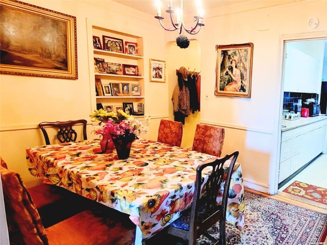 dining area with built in shelves and an inviting chandelier