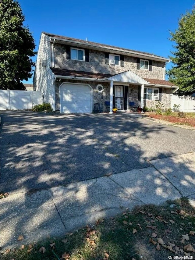 136 Acorn Ave, Central Islip, NY 11722 - view of front of home with stone siding, asphalt driveway, and an attached garage