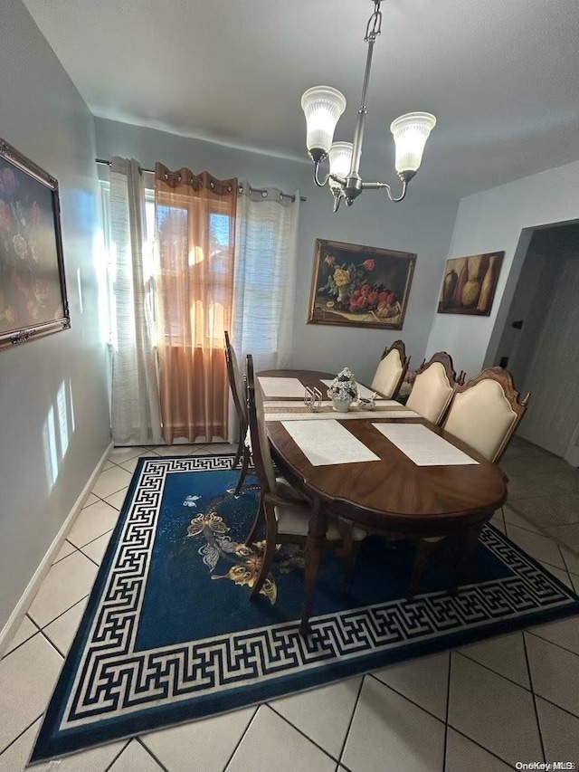 tiled dining space with a chandelier