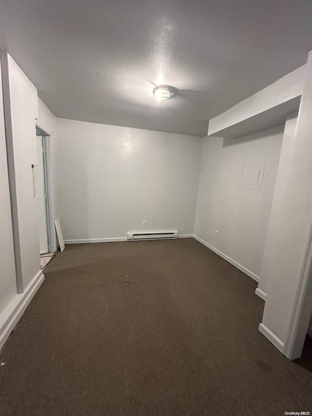 basement with a baseboard radiator and dark colored carpet