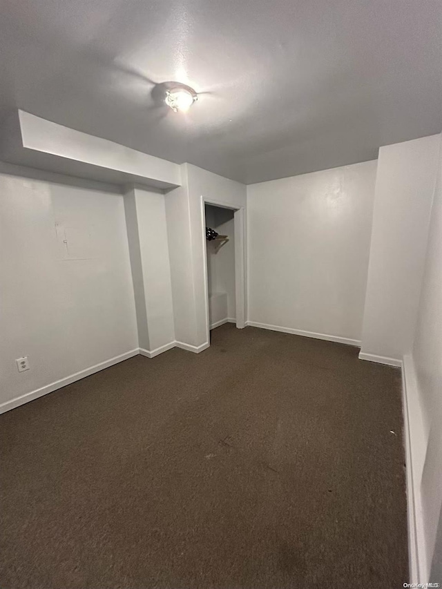 basement featuring dark carpet