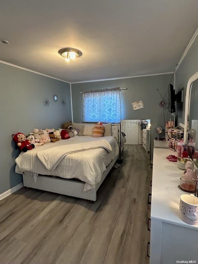 bedroom featuring hardwood / wood-style flooring and crown molding