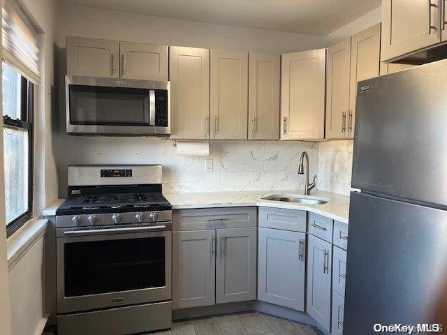 kitchen with tasteful backsplash, sink, plenty of natural light, and appliances with stainless steel finishes