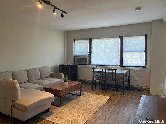 living room with hardwood / wood-style floors, cooling unit, and track lighting