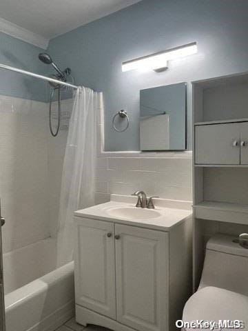 full bathroom with shower / tub combo, tasteful backsplash, vanity, tile walls, and toilet