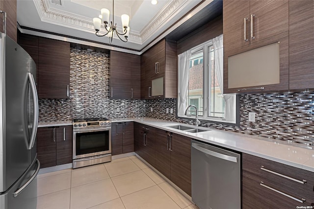 kitchen featuring sink, stainless steel appliances, decorative light fixtures, a tray ceiling, and light tile patterned floors