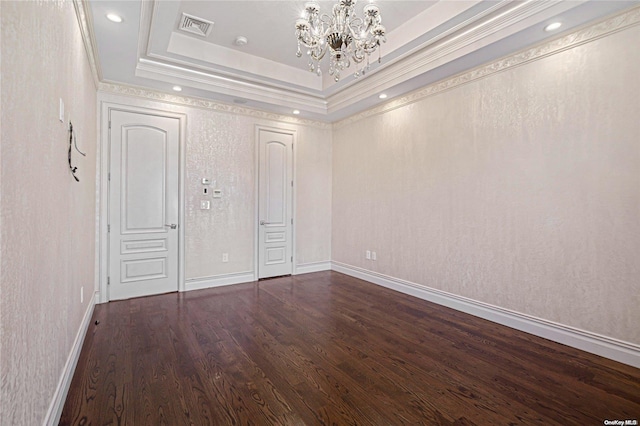 unfurnished bedroom with dark hardwood / wood-style floors, a raised ceiling, crown molding, and a chandelier