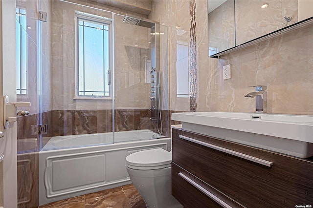 full bathroom featuring vanity, toilet, tile walls, and enclosed tub / shower combo