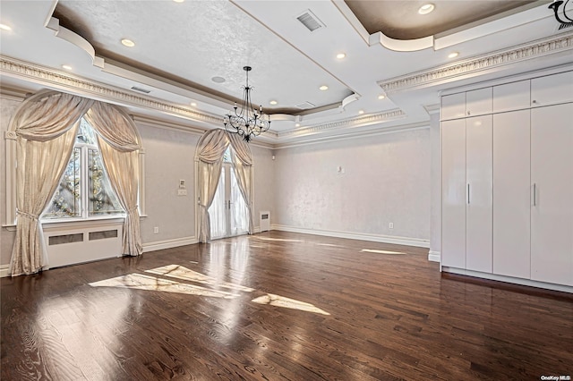 interior space with a tray ceiling, dark hardwood / wood-style floors, crown molding, and a notable chandelier