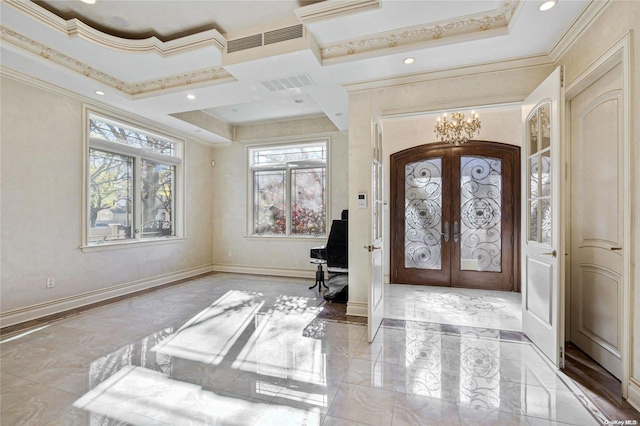 entryway featuring a chandelier, french doors, a raised ceiling, and crown molding