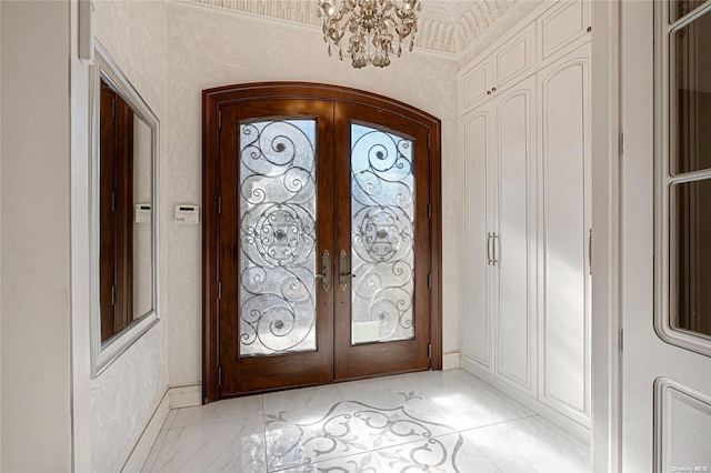 foyer featuring a chandelier, french doors, and ornamental molding