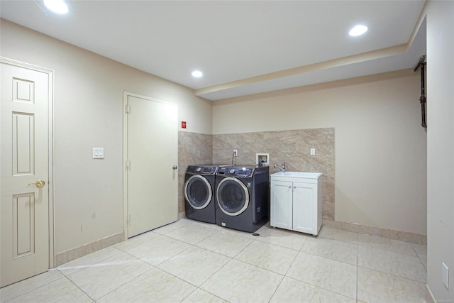 laundry room featuring sink, light tile patterned flooring, cabinets, and independent washer and dryer