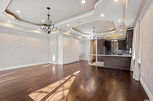 unfurnished living room with a tray ceiling, crown molding, and dark wood-type flooring