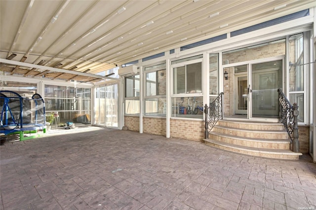 unfurnished sunroom with an AC wall unit