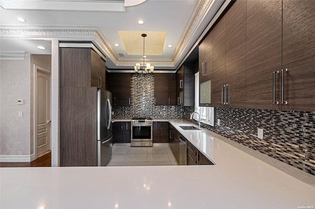 kitchen with pendant lighting, stainless steel appliances, light countertops, dark brown cabinetry, and modern cabinets